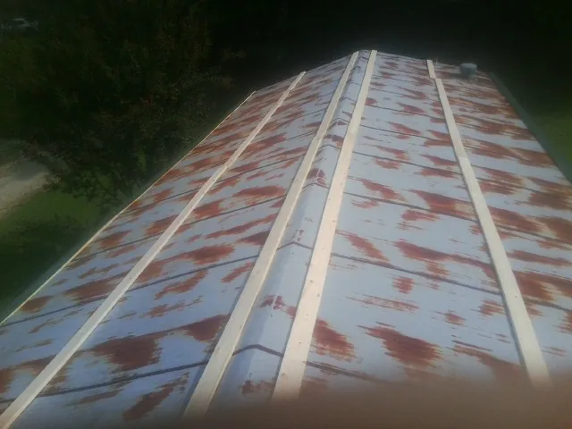 Rusted metal roof panels with new wood purlins before replacement — Storm Damage Roof Repair in Smiths Station by Roofing Brothers