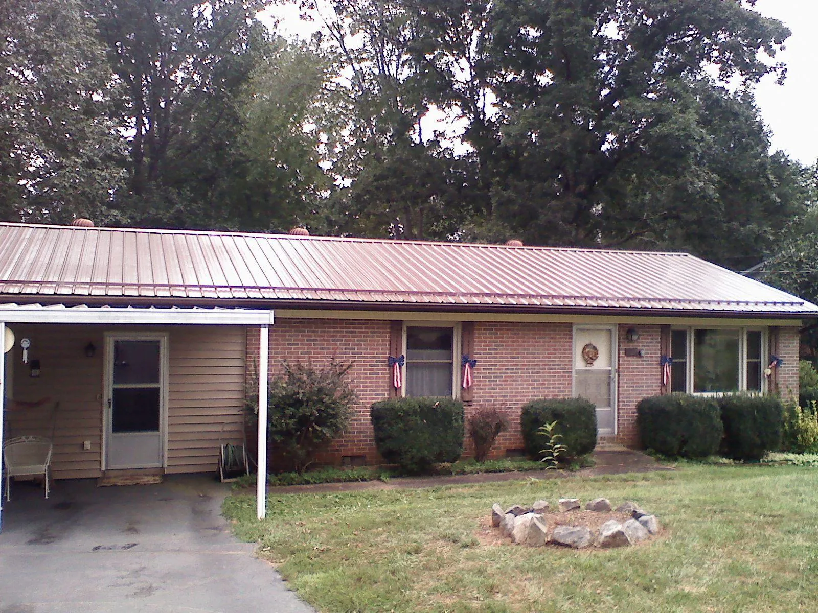 Bronze metal roof and carport on a brick ranch home — Roof Repair work by our crew in Smiths Station