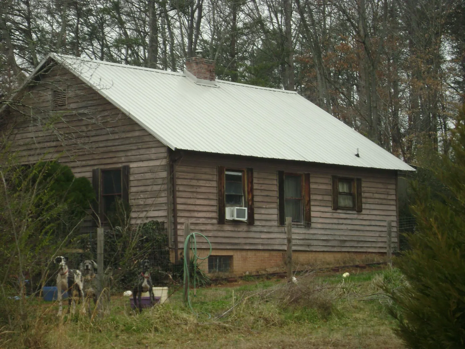 White metal roof on an old wood sided farmhouse, from a Metal Roof Installation job in Smiths Station